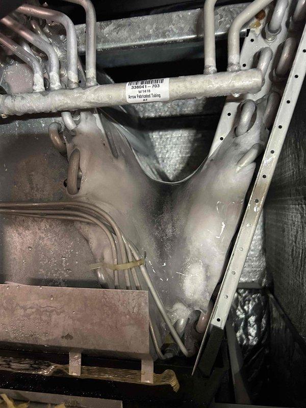 Responded to a no cooling complaint on a gas furnace with air conditioning system less than 10 years old that was struggling to maintain adequate cooling capacity. Performed comprehensive system diagnostics including inspection of the indoor air handler unit, refrigerant lines, and airflow measurements at supply registers. Documented system conditions with photographs of internal components showing refrigerant tubing connections and measured supply air temperatures at floor vents to assess cooling performance and identify the root cause of inadequate cooling.