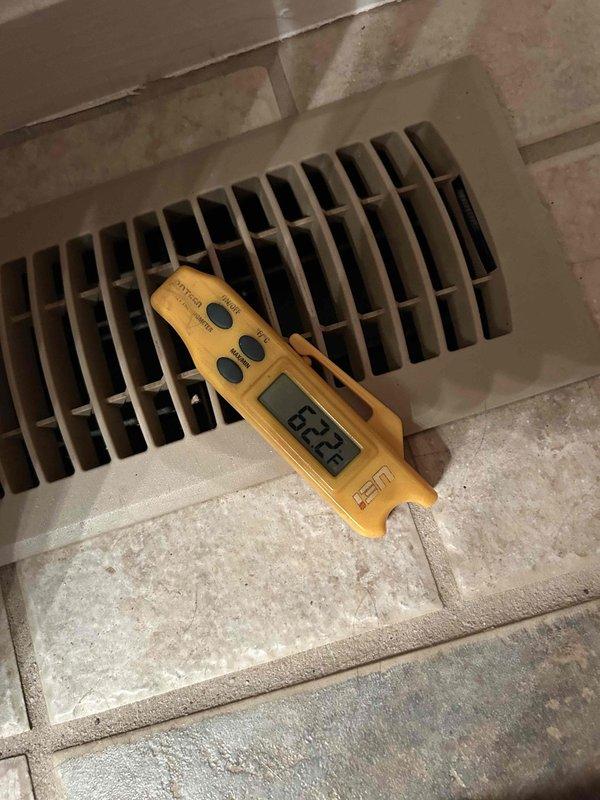 Responded to a no cooling complaint on a gas furnace with air conditioning system less than 10 years old that was struggling to maintain adequate cooling capacity. Performed comprehensive system diagnostics including inspection of the indoor air handler unit, refrigerant lines, and airflow measurements at supply registers. Documented system conditions with photographs of internal components showing refrigerant tubing connections and measured supply air temperatures at floor vents to assess cooling performance and identify the root cause of inadequate cooling.