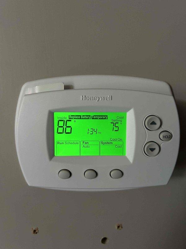 Responded to no cooling call on gas furnace with air conditioning system that had not been maintaining temperature for approximately one week. Upon arrival, found thermostat displaying 86°F actual temperature with 75°F setpoint, indicating significant temperature differential. Indoor unit located in crawlspace. Performed diagnostic evaluation of system including temperature measurements at supply registers, which recorded 72.6°F discharge air temperature. This reading indicates inadequate cooling capacity and suggests potential issues with refrigerant charge, airflow restriction, or compressor performance. Documented thermostat settings showing system in cooling mode with fan set to auto operation and low battery warning displayed. Further diagnostics required to isolate root cause of insufficient cooling performance.