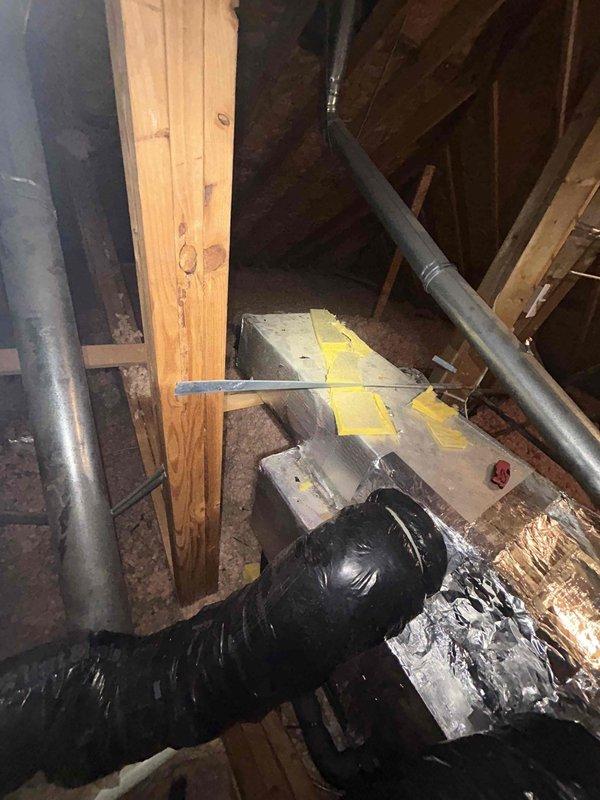 Responded to warranty call for new HVAC installation where one room was not receiving airflow. Upon inspection of attic space, identified improperly connected or disconnected flexible duct at metal plenum. Reconnected and secured black flexible ductwork to rectangular supply plenum using proper fastening methods and foil tape. Verified all duct connections were sealed and properly supported throughout the attic run. Tested system operation and confirmed adequate airflow restored to previously affected room. All ductwork now functioning as designed per original installation specifications.