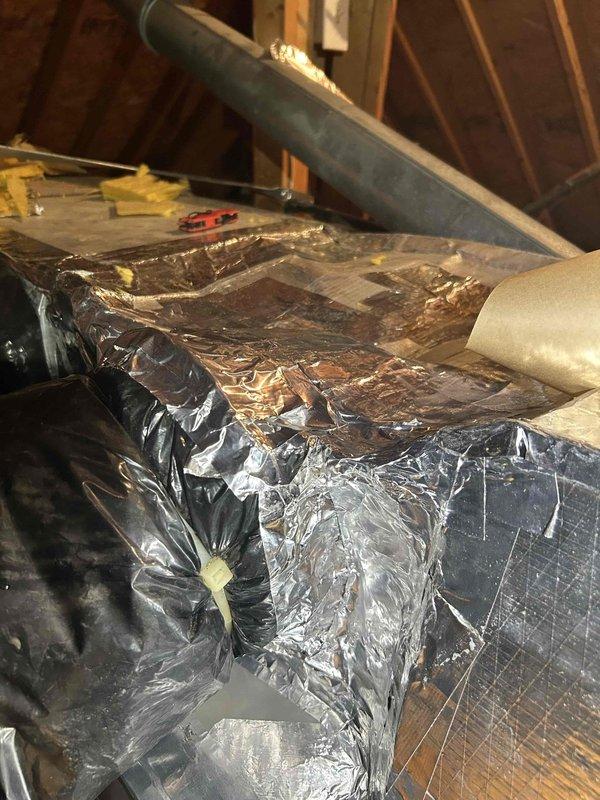 Responded to warranty call for new HVAC installation where one room was not receiving airflow. Upon inspection of attic space, identified improperly connected or disconnected flexible duct at metal plenum. Reconnected and secured black flexible ductwork to rectangular supply plenum using proper fastening methods and foil tape. Verified all duct connections were sealed and properly supported throughout the attic run. Tested system operation and confirmed adequate airflow restored to previously affected room. All ductwork now functioning as designed per original installation specifications.