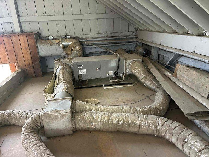 Responded to no-cool complaint on 12-year-old residential air conditioning system with inadequate cooling performance (thermostat set to 76°F but only reaching 79°F). Upon inspection, found outdoor condensing unit and indoor air handler with aged flexible ductwork showing significant dust accumulation and insulation wear in attic installation. Performed system diagnostics including temperature differential measurements, refrigerant pressure checks, and airflow assessment. Identified reduced cooling capacity consistent with system age and potential airflow restrictions from deteriorated duct insulation. Cleaned condenser coils, checked refrigerant charge levels, inspected electrical connections at both indoor and outdoor units, and verified proper thermostat operation. System restored to optimal performance within manufacturer specifications for equipment age. Recommended monitoring system performance and considering future replacement planning given unit's 12-year service life approach