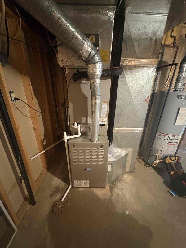Completed full residential air conditioning system replacement including installation of Bryant 5-ton 14.3 SEER2 single-stage outdoor condensing unit (model GA5SAN56000W) and matching Bryant evaporator coil (model CVAVA6021XMA) in basement mechanical room. Removed and properly disposed of existing equipment per environmental regulations. Installed new outdoor unit pad, electrical disconnect box, and electrical whip kit to ensure code-compliant power supply. Ran new refrigerant lines with proper insulation and installed refrigerant line filter drier for system protection. Fabricated and installed transition ductwork to connect new evaporator coil to existing duct system with proper sealing. Installed SS2 coil drain safety water sensor on condensate drain line to prevent water damage from potential drain blockages. Pulled all applicable permits and completed installation in compliance with local building codes. Evacuated refrigerant lines, charged system to manufacturer specifications, a