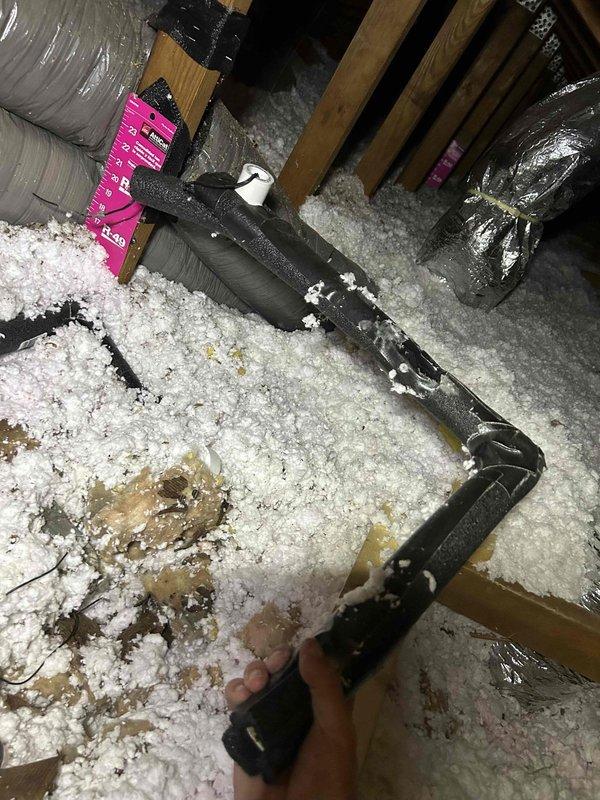 Responded to water leak complaint originating from ceiling-mounted indoor HVAC unit that had been actively leaking into hallway throughout the weekend. Accessed attic space and conducted thorough inspection of air handler, condensate drainage system, and surrounding ductwork. Examined flexible duct connections, electrical components including capacitor and junction box, and PVC condensate lines for signs of overflow or blockage. Documented conditions with photographs showing equipment installation, insulation displacement from moisture exposure, and overall system configuration. Identified source of water intrusion and assessed extent of leak impact on attic insulation and structural components.
