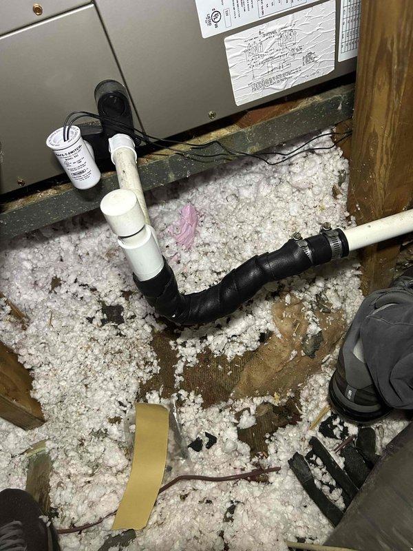 Responded to water leak complaint originating from ceiling-mounted indoor HVAC unit that had been actively leaking into hallway throughout the weekend. Accessed attic space and conducted thorough inspection of air handler, condensate drainage system, and surrounding ductwork. Examined flexible duct connections, electrical components including capacitor and junction box, and PVC condensate lines for signs of overflow or blockage. Documented conditions with photographs showing equipment installation, insulation displacement from moisture exposure, and overall system configuration. Identified source of water intrusion and assessed extent of leak impact on attic insulation and structural components.