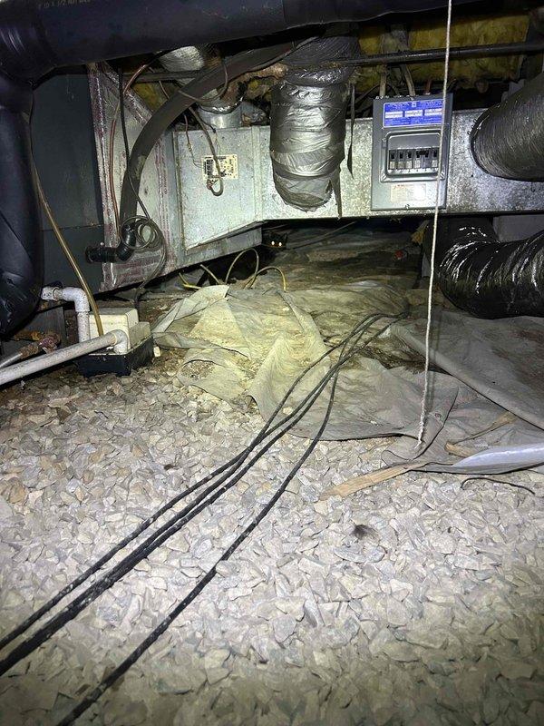 Responded to no cooling complaint on 15-year-old electric HVAC system with indoor unit located in crawlspace. Upon arrival, measured supply air temperature at floor register reading 62°F, indicating inadequate cooling performance. Accessed crawlspace and inspected air handler, ductwork, and associated components. Found extremely dirty air filter that had not been changed in approximately one year, causing restricted airflow and reduced system efficiency. Noted flex duct connections and insulation condition in attic space. Documented system conditions with thermal measurements and photographic evidence of equipment location and installation configuration.