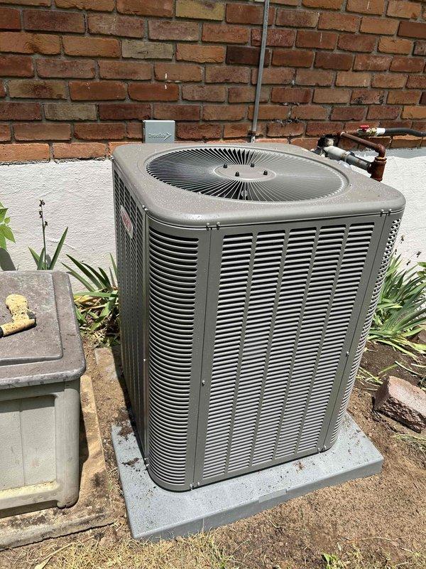 Completed residential air conditioning system installation featuring a Lennox ML14KC1-036-230 3-ton 15 SEER2 condensing unit and Lennox CK40CT-36B-71 evaporator coil. Removed and properly disposed of existing equipment per environmental regulations. Installed new outdoor condensing unit on concrete pad with proper leveling and positioning against exterior brick wall. Ran electrical whip from new disconnect box to unit and verified proper voltage and amperage. Flushed existing refrigerant line set to remove contaminants and reused for new system installation. Installed new evaporator coil in basement air handler location with proper transitions to existing ductwork. Applied refrigerant line insulation to suction line at outdoor unit to prevent condensation and energy loss. Sealed penetration in foundation where line set passes through to prevent air infiltration and pest entry. Installed refrigerant line filter drier to protect system from moisture and contaminants. Added SS2 coil drain