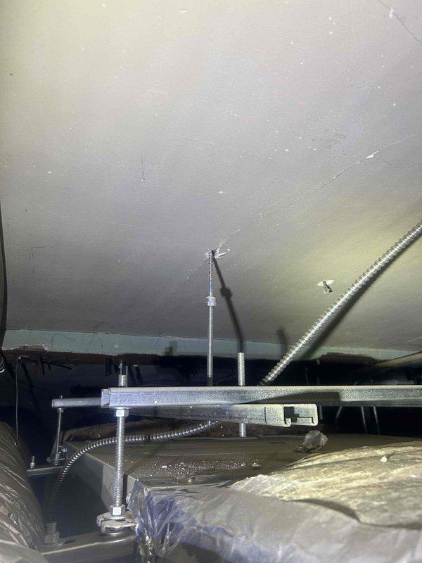 Responded to water leak complaint originating from HVAC system in drop ceiling area. Upon inspection, identified condensation issue on supply ductwork causing water dripping. Documented existing conditions including flex duct installation, mounting hardware, and insulation configuration in attic space. Advised customer of condensation source and recommended solutions to prevent future moisture accumulation on ductwork.