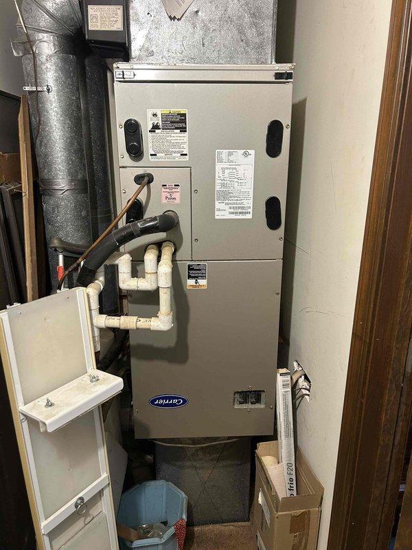 # No Cool Service Call - 20-Year-Old Carrier System

Responded to no cooling complaint on approximately 20-year-old Carrier split system. Performed diagnostic evaluation of both indoor air handler and outdoor condensing unit to isolate failure point. 

Upon inspection, accessed indoor evaporator coil assembly housed in vertical air handler cabinet. Coil showed age-related wear consistent with two decades of operation. Examined finned heat exchanger surfaces for blockage, damage, or deterioration. Assessed refrigerant line connections, condensate drainage system including PVC trap configuration, and electrical connections at unit.

Evaluated overall system condition noting advanced age of equipment at end of expected service life. Documented equipment nameplate data and current operational status. Photographed evaporator coil assembly and complete air handler installation including associated ductwork, refrigerant lines, and drainage piping for service records.

Provided customer with d