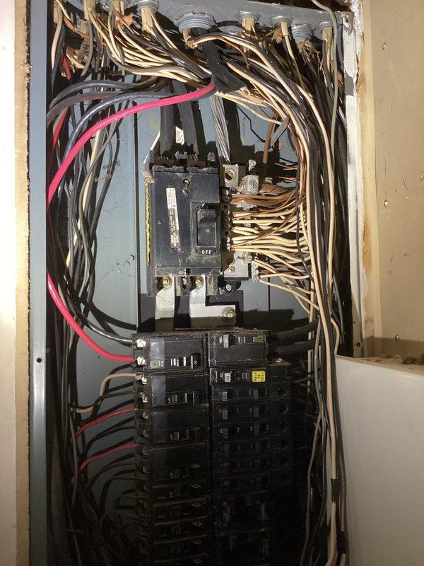 Conducted on-site electrical assessment for generator installation. Evaluated existing electrical infrastructure including main service panel with analog meter, conduit routing, and current circuit breaker configuration. Documented main distribution panel condition showing aged main breaker and multiple branch circuits with extensive wiring connections. Photographed meter base location on brick wall with existing conduit pathways to determine optimal connection points for proposed generator transfer switch. Assessed available panel capacity and identified necessary upgrades to accommodate automatic transfer switch integration with existing electrical system.