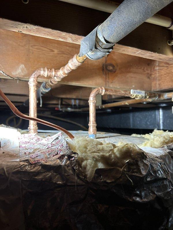Conducted follow-up inspection of recently completed water heater replacement to address customer concerns regarding installation procedures and standing water in crawl space. Documented water heater installation with detailed photographs showing proper placement on concrete pad, copper piping connections with support brackets, insulated supply lines, and drain pan positioning between floor joists. Verified proper drainage procedures were followed during original installation and confirmed standing water observed by customer was unrelated to water heater removal process.