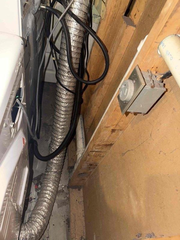 Conducted electrical inspection of 25-year-old residential property in response to customer concerns regarding possible incorrect wiring on unspecified appliances. Performed comprehensive visual assessment of electrical systems in attic utility space and laundry area, examining electrical cables, junction boxes, and appliance connections serving HVAC equipment and laundry appliances. Inspected bundled electrical cables routed along wooden framing, verified proper connections at electrical junction box and disconnect switch, and assessed wiring integrity at appliance locations. Documented existing electrical installation conditions with photographic evidence for customer records and future reference.