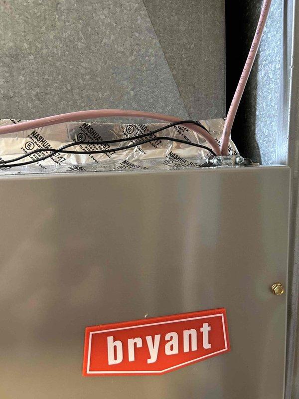 Completed full HVAC system installation for new condo construction, installing a Bryant 2-ton 14.3 SEER2 heat pump system. Installed outdoor unit model GH5SAN52400A on new concrete pad with snow legs for elevation and protection. Mounted indoor air handler model FJ5ANXB24L00 with integrated 10KW electric heat kit model TU-EC-10BKB in attic space. 

Ran new dedicated electrical wiring from breaker panel to heat pump outdoor unit to meet code requirements for the system. Installed electrical disconnect box at outdoor unit and electrical whip kit for proper connections. Set refrigerant lines with proper insulation and installed refrigerant line filter for system protection. Connected and insulated copper refrigerant tubing between outdoor and indoor units.

Installed condensate drain trap and SS2 coil drain safety water sensor on air handler. Added "Ceiling Saver" overflow drain pan with secondary water sensor beneath unit for leak protection. Fabricated and installed transition ductwork 