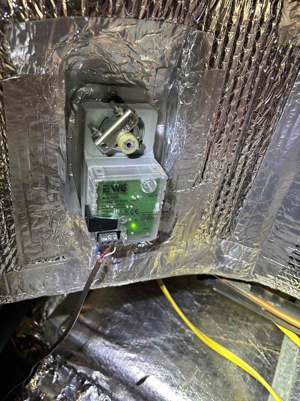 Responded to no cooling complaint on aging Carrier geothermal heat pump system. Upon inspection, found system operational but identified zone damper actuator requiring attention in the ductwork. Verified ground loop connections, circulation pumps, and indoor air handler components. Documented existing equipment configuration including dual pump setup and zone control damper system. System assessed and customer advised of findings.
