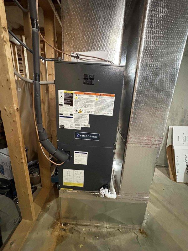 Completed full residential heat pump system installation featuring Friedrich Breeze 18 SEER2 variable stage 3-ton heat pump system with variable speed air handler (model WFPU17Y363D), outdoor heat pump unit (model WFH36Y193D), and 15kW auxiliary heat kit (model AUX15KWA). Removed and properly disposed of existing HVAC equipment per code requirements. Installed outdoor unit on new concrete pad with snow legs for elevated clearance and protection. Set up electrical disconnect box and whip kit to outdoor unit with proper circuit protection. Ran insulated refrigerant lines between outdoor and indoor units with inline refrigerant line filter for system protection. Mounted variable speed air handler in basement location against wall framing with secure fastening. Installed auxiliary electric heat kit within air handler cabinet for supplemental heating capacity. Connected metallic supply ductwork with proper transitions to existing duct system. Installed drain trap, SS2 coil drain safety wate