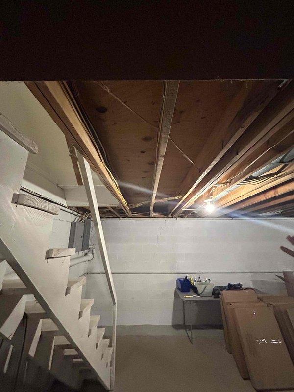 Conducted on-site evaluation for tankless gas water heater installation in residential property. Assessed existing basement utility area including current plumbing infrastructure, gas line accessibility, and venting requirements. Documented existing HVAC system placement, electrical panel location, and available wall space for tankless unit mounting. Evaluated ceiling-mounted water supply lines and drainage configuration to determine connection points and required modifications. Measured clearances and identified optimal installation location considering manufacturer specifications for combustion air, venting pathways, and service access. Photographed existing conditions including structural support posts, exposed joists, and utility routing to develop comprehensive installation plan and material requirements for tankless water heater conversion.