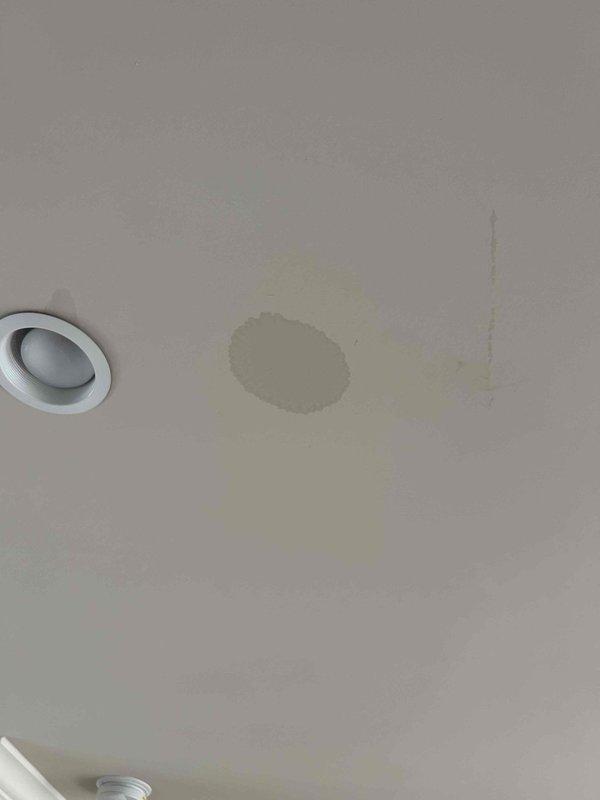 Responded to service call for water damage on ceiling below attic-mounted HVAC unit. Upon inspection, confirmed active water staining with yellowish-brown discoloration indicating moisture infiltration from above. Accessed attic space and located indoor air handler with condensate drainage system. Identified compromised drain pan showing signs of overflow due to primary condensate drain line obstruction. Cleared blockage from PVC condensate line, verified proper drainage flow, and inspected drain pan for cracks or damage. Tested system operation through complete cooling cycle to ensure condensate is properly draining and no further leakage is occurring. Recommended monitoring ceiling stain for any expansion and advised that existing cosmetic damage will require separate repair once area has fully dried.