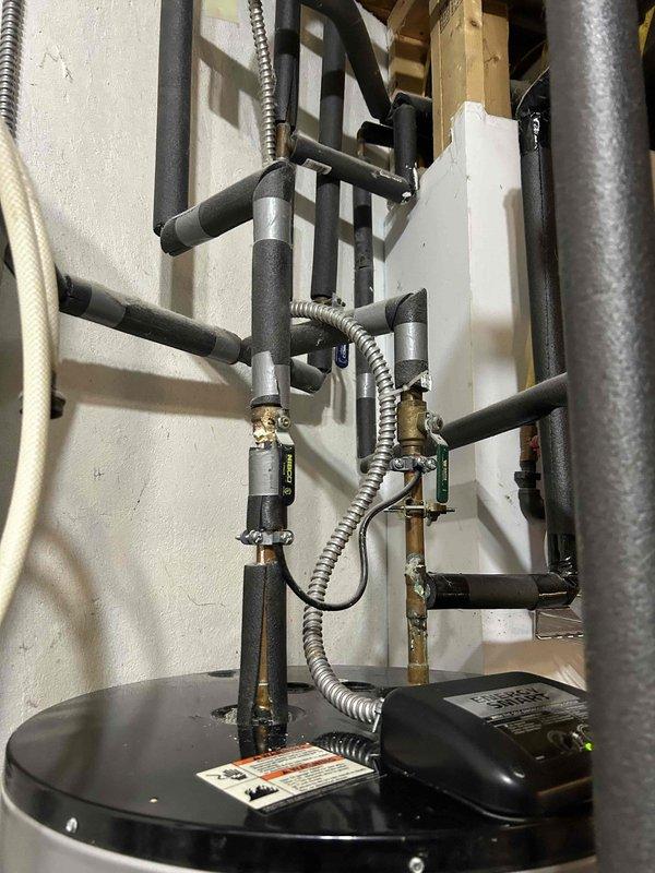 Responded to emergency service call for 20-year-old 80-gallon electric water heater with water leaking from access panels in mechanical room. Upon inspection, confirmed active leaking from tank body, indicating internal tank failure typical of units at end of service life. Due to age of unit, extent of corrosion, and customer's request for same-day resolution, recommended full replacement rather than repair. Removed existing failed water heater and installed new 80-gallon electric residential water heater in same location. Connected all supply and discharge plumbing lines, verified proper electrical connections, installed new temperature and pressure relief valve with appropriate discharge piping, and ensured all code-compliant safety features were in place. Filled tank, purged air from system, tested all connections for leaks, and verified unit achieved proper operating temperature. Cleaned work area and removed old water heater from premises. System fully operational upon completion.