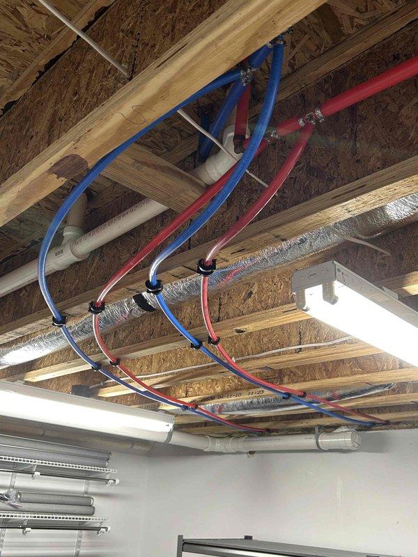 Completed comprehensive plumbing installation involving four separate fixture additions. Accessed basement ceiling to locate existing cold water line, drilled through exterior wall at back left corner of home, and installed Woodford brand 10-inch wall-mounted spigot with 1/2-inch PEX supply line run from nearest cold water source.

Performed garage washer box installation by cutting drywall to access existing plumbing infrastructure. Installed complete washer box assembly with hot and cold water hookups and 2-inch drain line. Teed into existing 2-inch drain line within wall cavity and connected to existing hot and cold water supply lines. Minimized drywall cuts during installation.

Installed second washer box in basement as surface-mount installation on exterior of drywall. Tied new drain into existing 4-inch main drain line and ran vent piping to connect with shower vent in open ceiling area. Ran new PEX hot and cold water supply lines to washer box location.

Installed yard hydrant 