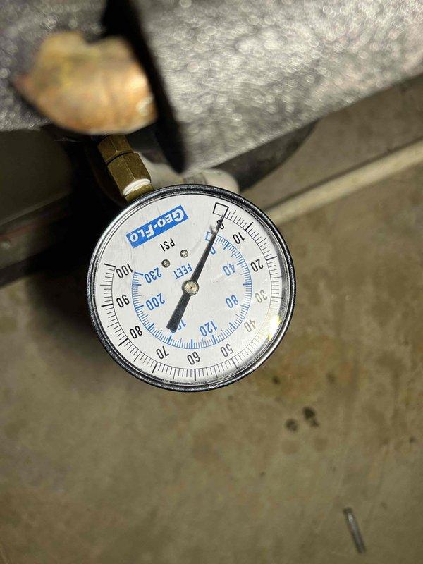 Conducted follow-up inspection of geothermal loop system to verify pressure stability after water was added during previous monthly maintenance visit. Inspected HeatMaster circulation equipment and monitored system pressure using installed gauge, which maintained stable readings with no indication of pressure loss or active leaks in the hydronic loop.