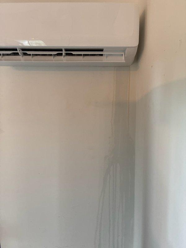 Responded to service call regarding water leakage from wall-mounted ductless mini-split system causing visible damage to interior walls and ceiling. Upon arrival, confirmed active moisture issue with dark vertical staining running down wall beneath unit and water marks present on ceiling. Inspected mini-split installation and identified condensate drainage problem requiring immediate attention to prevent further water damage to building structure.