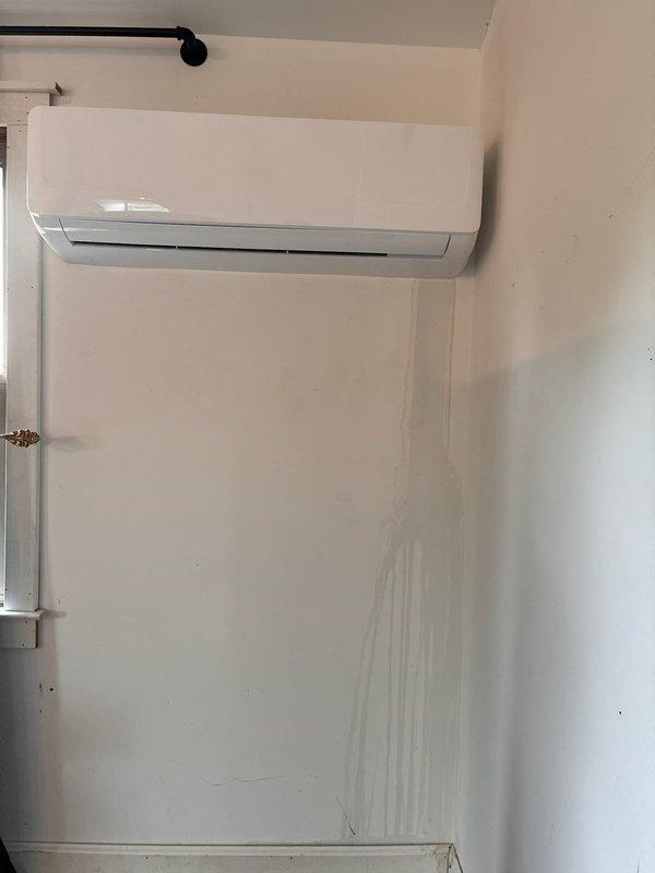 Responded to service call regarding water leakage from wall-mounted ductless mini-split system causing visible damage to interior walls and ceiling. Upon arrival, confirmed active moisture issue with dark vertical staining running down wall beneath unit and water marks present on ceiling. Inspected mini-split installation and identified condensate drainage problem requiring immediate attention to prevent further water damage to building structure.