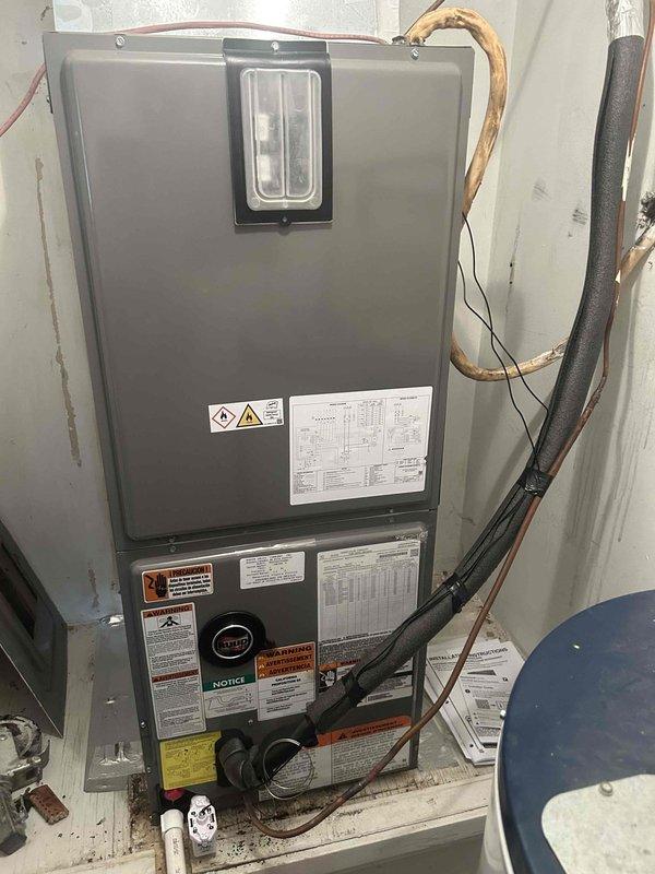 Completed full residential HVAC system installation including RUUD 2.5-ton heat pump (model RP14AY30AJ2NA), RUUD 2.5-ton air handler (model RH2TY3617STANNJ), and RUUD 5kW heat kit (model RXBH-1724A05J-B) with digital thermostat. Installed outdoor unit on concrete pad with snow legs, electrical disconnect box, and electrical whip kit. Applied refrigerant line insulation and installed refrigerant line filter. Mounted indoor air handler in utility closet with proper refrigerant line connections and secured copper lines with metal brackets. Installed condensate drain trap with SS2 coil drain safety water sensor for overflow protection. Fabricated transition to connect new equipment to existing ductwork and installed standard-sized air filter rack for system protection. Completed all electrical connections including proper wire routing and control wiring to new digital thermostat. Pulled applicable permits and ensured all work met current code compliance standards. Removed and properly disp