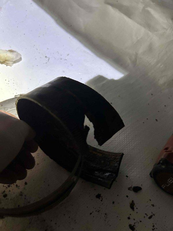 Responded to service call for broken pipe in crawl space. Upon inspection, discovered damaged black rubber coupling connecting ductwork sections had failed, causing separation of the joint. Removed deteriorated rubber connector with attached metal clamp and replaced with new coupling to restore proper connection. Secured all components with appropriate hose clamps and verified system integrity upon completion.