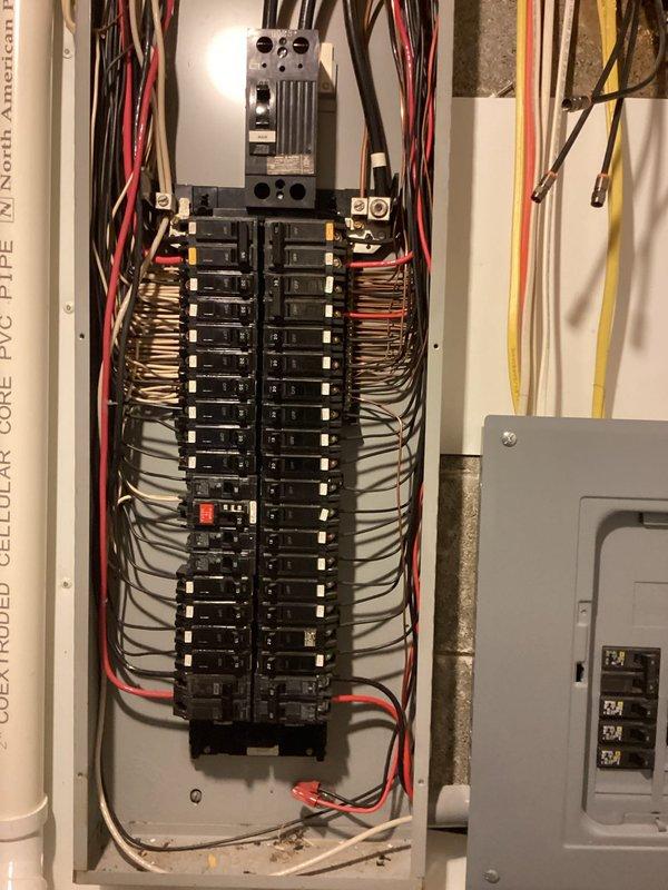 Completed electrical estimate for running new line to breaker panel in basement. Assessed existing electrical infrastructure including main breaker panel with multiple circuits, adjacent subpanel, and overhead conduit routing along exposed joists. Evaluated current panel capacity, wire gauge requirements, and optimal routing path for new circuit installation while maintaining code compliance and proper load distribution across existing breaker configuration.