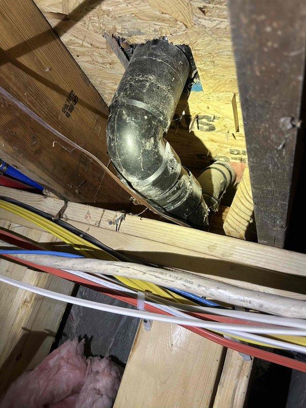 Responded to complaint of sewage odor in second-level guest bathroom with gurgling sounds heard in basement. Inspected plumbing system and identified inadequate venting as the source of sewer gas infiltration. Located plumbing vent stack penetration in attic space showing improper sealing around pipe boot, allowing sewer gases to escape into wall cavity and migrate to occupied spaces. Inspected basement floor drain which exhibited severe corrosion and deteriorated trap seal, contributing to odor issues and gurgling sounds due to air pressure imbalances in the drainage system. Documented conditions of both vent stack penetration and corroded floor drain assembly for recommended repairs to restore proper venting and eliminate sewer gas odors.