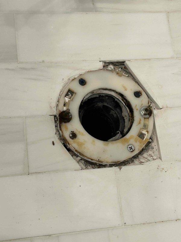 Responded to complaint of sewage odor in second-level guest bathroom with gurgling sounds heard in basement. Inspected plumbing system and identified inadequate venting as the source of sewer gas infiltration. Located plumbing vent stack penetration in attic space showing improper sealing around pipe boot, allowing sewer gases to escape into wall cavity and migrate to occupied spaces. Inspected basement floor drain which exhibited severe corrosion and deteriorated trap seal, contributing to odor issues and gurgling sounds due to air pressure imbalances in the drainage system. Documented conditions of both vent stack penetration and corroded floor drain assembly for recommended repairs to restore proper venting and eliminate sewer gas odors.