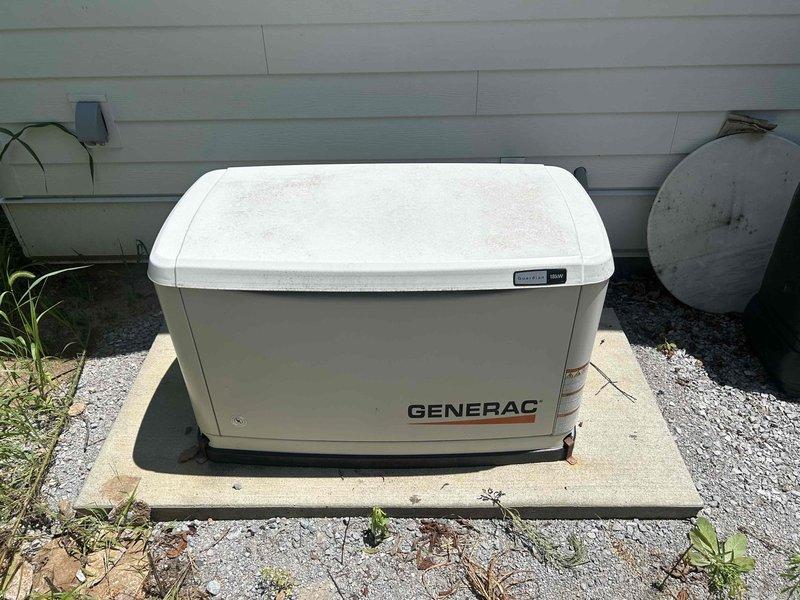 Performed routine maintenance on an 18KW Generac residential standby generator connected to propane fuel supply. Conducted comprehensive system inspection including visual assessment of generator housing, transfer switch components, and electrical connections. Documented unit condition with photographs showing proper installation on concrete pad, adequate clearances from structure, and secure propane tank proximity. Inspected transfer system data label and verified neutral bonding configuration within automatic transfer switch panel. Confirmed all wire terminations at neutral bus bar were secure and properly organized. Checked control module LED indicators and system status lights for proper operation.