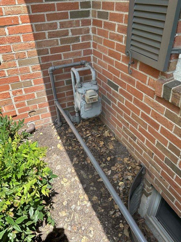 Installed new gas piping system from existing natural gas meter to standby generator unit, including routing gray metal pipe along exterior brick wall with proper mounting and support. Installed dedicated shut-off valve for generator isolation, pressure tested entire gas line assembly for leaks, and verified proper operation of generator upon system activation.