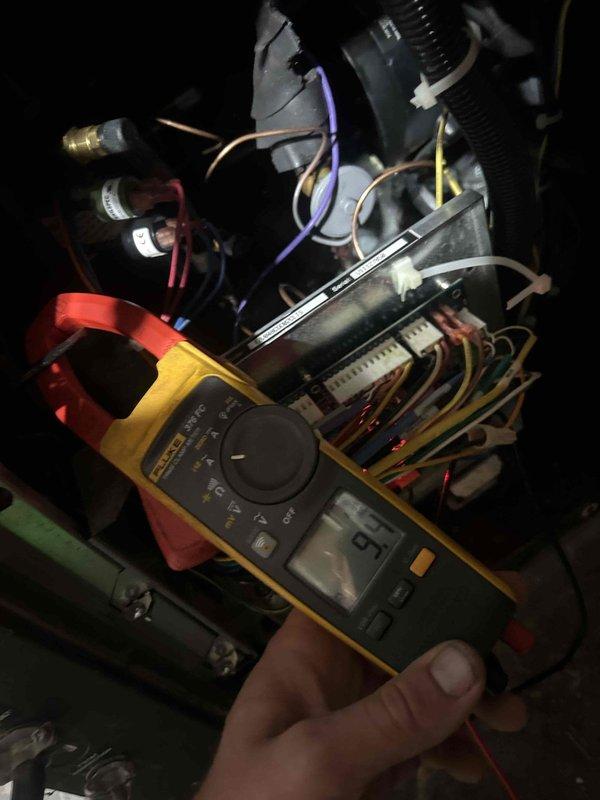 Responded to no cooling complaint on 8-year-old geothermal system blowing warm air. Performed diagnostic testing on control board and electrical components using multimeter to measure voltage and current at various connection points. Inspected PCB with illuminated status LEDs, traced multiple wire connections throughout control panel, and evaluated system operation. Identified issue with geothermal heat pump control system preventing proper cooling mode operation.
