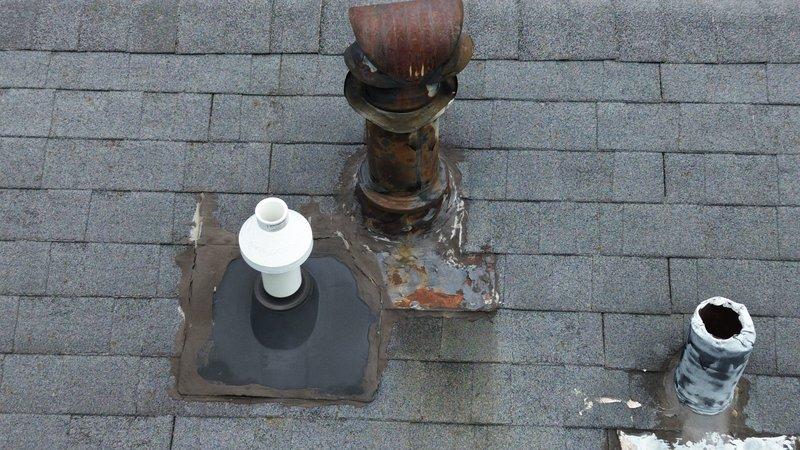 Completed estimate for roof vent pipe repairs on residential property. Inspection revealed three roof penetrations in varying conditions: one white PVC plumbing vent with weathered flashing, one heavily corroded metal chimney pipe with significant rust damage and deteriorated flashing causing staining on surrounding shingles, and one damaged white PVC pipe with broken top section. Provided quote for replacement of rusted metal vent stack, repair of damaged PVC pipe, and replacement of compromised flashing materials to prevent water intrusion and restore proper venting function.