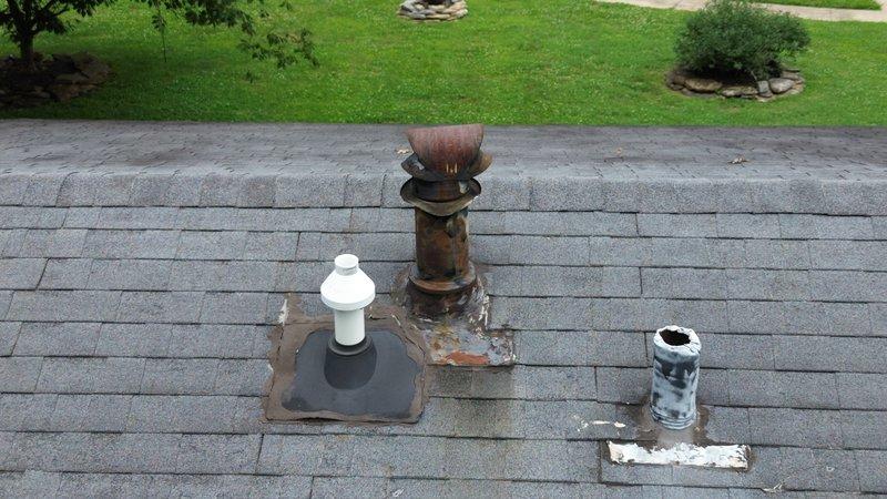 Completed estimate for roof vent pipe repairs on residential property. Inspection revealed three roof penetrations in varying conditions: one white PVC plumbing vent with weathered flashing, one heavily corroded metal chimney pipe with significant rust damage and deteriorated flashing causing staining on surrounding shingles, and one damaged white PVC pipe with broken top section. Provided quote for replacement of rusted metal vent stack, repair of damaged PVC pipe, and replacement of compromised flashing materials to prevent water intrusion and restore proper venting function.