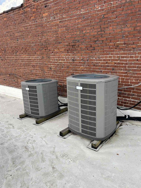Performed comprehensive maintenance tune-up on two rooftop HVAC units accessed via ladder from interior office space. Completed full system inspection, documented equipment specifications including filter and belt sizes for both units, photographed condenser units positioned on concrete pad with refrigerant line connections, and recorded all necessary information to establish ongoing preventative maintenance program.