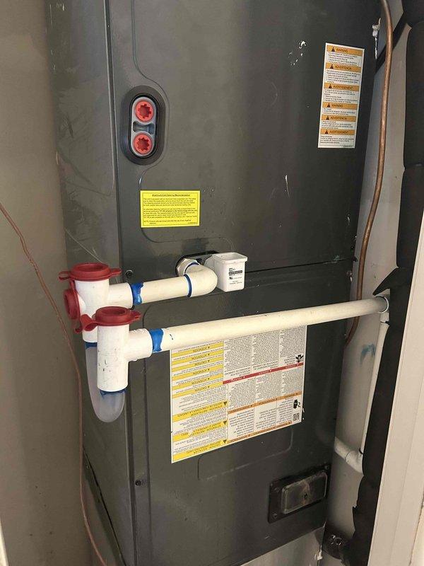 Responded to water leak complaint originating from upstairs utility closet and manifesting at first floor ceiling. Upon inspection, identified active leak at ceiling-wall junction with visible water damage and separation in drywall. Traced source to air handler unit in upstairs mechanical room. Inspected condensate drain system including PVC piping, coupling joints, and drain fittings. Documented equipment condition and leak points with photographic evidence for customer approval of recommended repairs.