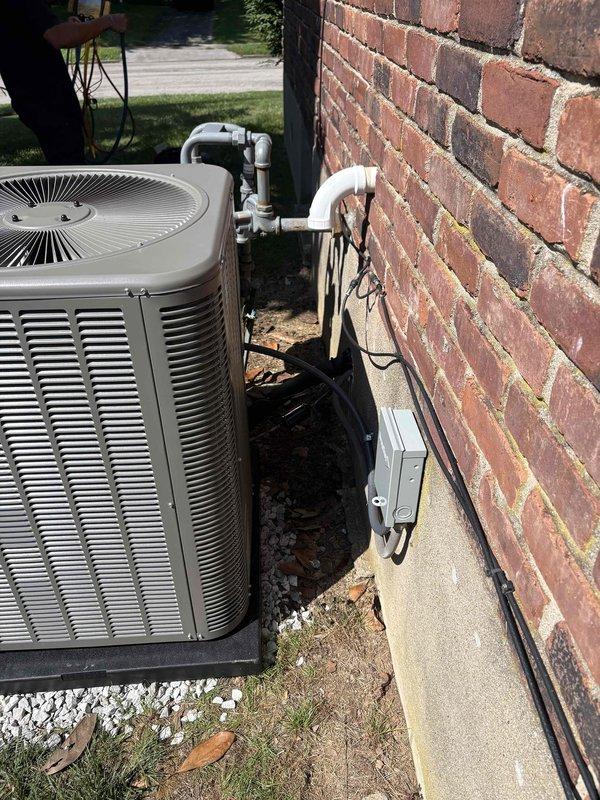 Completed full HVAC system installation including a Lennox ML14KC1-024-230 2-ton 15 SEER2 air conditioning condenser unit and Lennox CK40CT-18/24B-71 evaporator coil. Removed and properly disposed of existing equipment, then installed new outdoor condenser unit on concrete pad with gravel base alongside brick exterior wall. Mounted electrical disconnect box on wall with conduit run and installed electrical whip kit for power connection. Installed evaporator coil in air handler with transition to existing ductwork, including refrigerant line insulation and filter drier. Ran and insulated refrigerant lines between outdoor and indoor units, then evacuated system and charged to manufacturer specifications. Installed SS2 coil drain safety water sensor for secondary drain pan protection. Integrated system with existing thermostat, verified all electrical connections, and performed complete operational testing of cooling cycle. All work completed per code requirements with applicable permits 