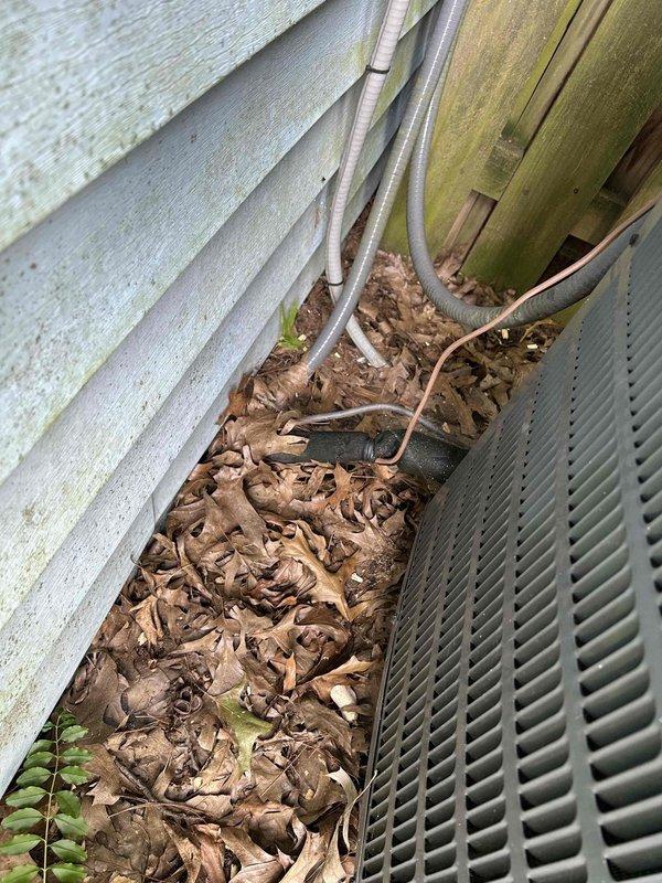 Responded to service call for air conditioning system with fan running continuously even when thermostat was set to off position, requiring breaker shutdown to stop operation. Upon arrival, inspected 9-year-old air conditioning unit and associated components. Found significant debris accumulation around exterior unit base restricting airflow and proper drainage. Observed condensation issues on indoor air handler with moisture buildup on metal surfaces indicating potential drainage concerns.

Diagnosed faulty thermostat control circuit preventing proper fan relay operation. Tested thermostat wiring and relay functionality at air handler. Cleared leaf debris and organic matter from around outdoor unit base and foundation area to restore proper airflow and prevent future moisture intrusion. Addressed condensation drainage concerns at indoor air handler. Corrected thermostat control circuit issue to restore proper fan cycling operation. Verified system responds correctly to thermostat comm