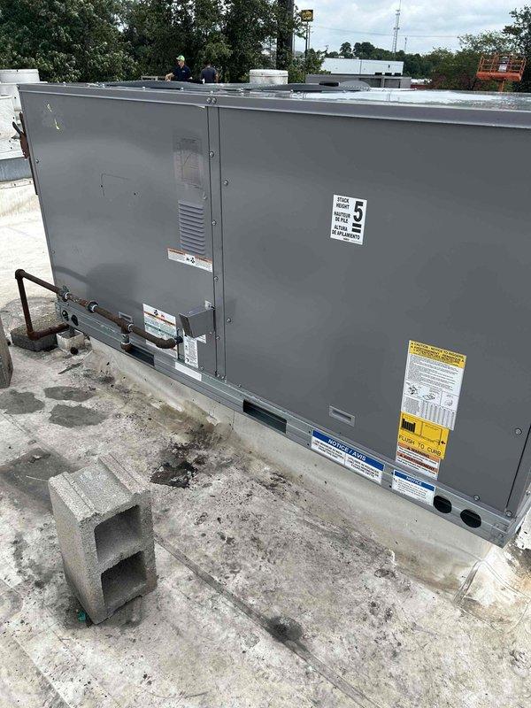 Completed commercial rooftop unit replacement on a flat roof concrete pad, installing client-provided Carrier WeatherMaker packaged air conditioning system utilizing crane services for safe placement. Integrated miscellaneous connection materials including electrical conduit, drainage components, and mounting hardware to secure the RTU to the rooftop surface. All work performed to manufacturer specifications with one-year labor warranty provided on the installation.