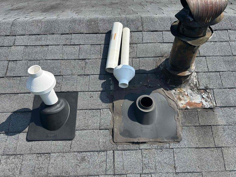 Replaced deteriorated concentric vent kit on roof due to active water intrusion that was initially suspected to be an old stain but confirmed to be an active leak. Relocated vent penetration approximately 5 feet from original position, drilled new roof penetration, and installed new concentric vent kit with proper flashing and sealing. Removed old damaged flashing and vent components showing significant weathering, rust, and compromised rubber boot deterioration. Secured roof area with tarp for temporary weather protection until roofing contractor can return to install shingles over new flashing and repair original penetration location.