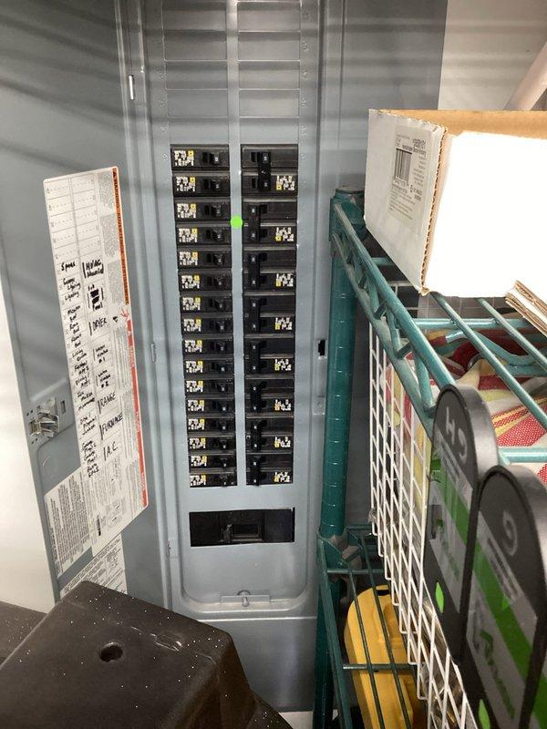 Conducted comprehensive electrical site assessment for standby generator installation at residential property. Evaluated existing 200-amp main electrical panel with dual-column breaker configuration to determine load capacity and optimal integration point for automatic transfer switch. Documented current electrical infrastructure including circuit distribution and panel condition. Assessed exterior installation location adjacent to HVAC condenser unit on concrete pad, noting adequate clearance from structure and accessibility for fuel line connection and maintenance access. Verified utility marking flags indicating safe excavation zones for electrical conduit routing and potential gas line installation from meter to proposed generator location.