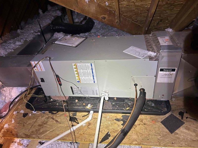 Responded to service call for thermostat not maintaining setpoint of 74 degrees. Performed diagnostic evaluation of HVAC air handler unit located in attic space. Utilized Fieldpiece SC260 clamp meter to measure electrical current and voltage at capacitor terminals, recording 0.55 amp reading. Inspected air handler cabinet, ductwork connections, and associated electrical components including motor run capacitor rated at 5.0 µF 440/370V. Documented equipment condition and system operation with photographs for service records.
