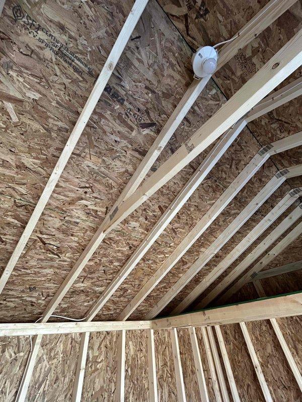 Completed electrical rough-in installation in unfinished attic space, installing one GFCI outlet, one duplex receptacle, one single-pole switch, one keyless light fixture with bulb, and one SJ cord with male cord cap. All devices were properly mounted to structural framing per code requirements, with junction boxes securely fastened to studs and joists in the exposed construction area.