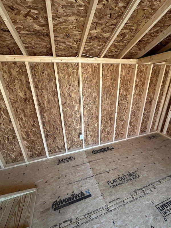 Completed electrical rough-in installation in unfinished attic space, installing one GFCI outlet, one duplex receptacle, one single-pole switch, one keyless light fixture with bulb, and one SJ cord with male cord cap. All devices were properly mounted to structural framing per code requirements, with junction boxes securely fastened to studs and joists in the exposed construction area.
