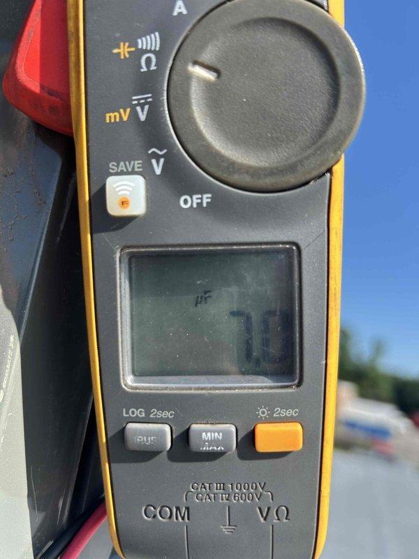 Responded to service call for HVAC system producing abnormal noise at commercial facility. Upon arrival, located affected unit mounted above interior wall with connected spiral ductwork. Performed diagnostic testing using digital multimeter, measuring capacitor at 70 microfarads to verify compressor and fan motor electrical components. Inspected rooftop outdoor condensing units and attic-mounted equipment as part of system assessment. Captured documentation of testing procedures and equipment location for service records.