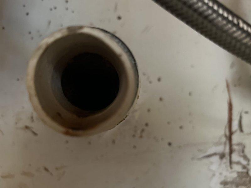 Responded to recurring kitchen sink drain clog in a 1974-built home with suspected pipe damage approximately 20 feet downstream under concrete slab. Upon arrival, assessed access options and determined roof vent access was feasible, eliminating the need to work through the kitchen sink fixture inside the home. Deployed sewer camera through roof vent to locate and identify the obstruction and confirm suspected pipe deterioration in the underground section. Utilized drain snake equipment via roof vent access point to clear the blockage affecting the kitchen drain line. Successfully restored proper drainage flow and documented findings with photographic evidence showing significant mineral buildup and rust-colored deposits within the drain system, consistent with aging cast iron or galvanized piping typical of the home's construction era. Communicated findings and completion status to customer via phone as requested.
