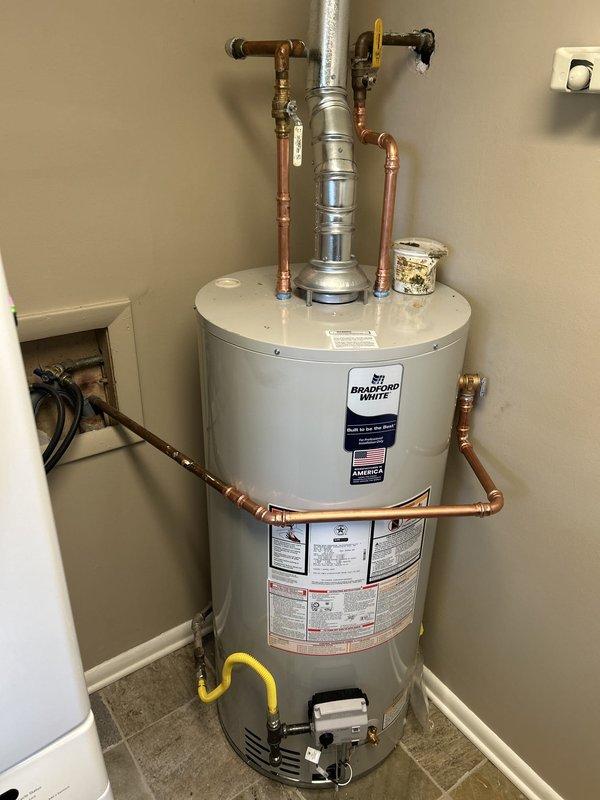 Completed installation of Bradford White 40-gallon gas water heater (22" x 48 1/16" short model) in residential utility space. Removed and disposed of existing water heater, then installed new unit with all necessary copper piping, fittings, and connections to existing water supply lines. Reconnected flexible gas line with appropriate shutoff valve, installed expansion tank at top of unit, and reconnected electrical supply for ignition system. All work performed in compliance with code requirements, including obtaining proper plumbing permit and scheduling inspection.