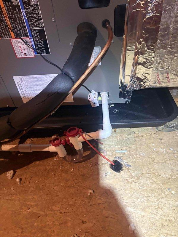 Completed full HVAC system installation in attic consisting of Lennox ML14KP1-024 2-ton single stage heat pump outdoor unit, CBK45UHET-024 constant torque air handler, and 10KW electric heat kit with S200 thermostat. Installed outdoor unit on new pad with snow legs, electrical disconnect box, and electrical whip kit. Applied refrigerant line insulation and installed refrigerant line filter on copper lines connecting outdoor and indoor units. Mounted air handler in attic with transition connections to existing ductwork and installed standard-sized air filter rack for system maintenance access.

Installed complete condensate drainage system including P-trap configuration with PVC piping, SS2 coil drain safety water sensor, and "Ceiling Saver" overflow drain pan equipped with secondary water sensor for leak protection. All drainage components positioned in black secondary drain pan as photographed. Obtained applicable permits and ensured all work met code compliance standards. Removed and